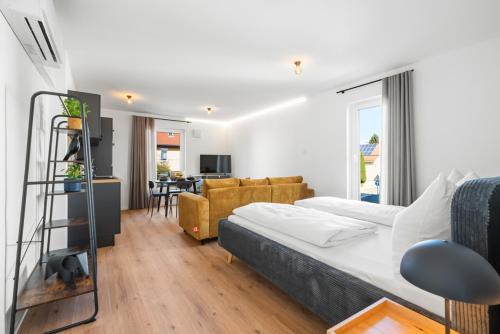 a bedroom with a bed and a living room at Studio 03 - Einzimmerapartment klimatisiert in Friedrichshafen