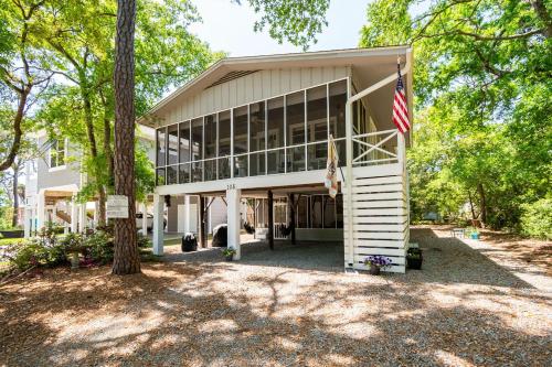 a house with an american flag in front of it at Beaching & Griping by Oak Island Accommodations in Oak Island