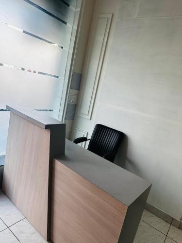 a desk in an office with a black chair at Hotel Loya Bti in Bathinda