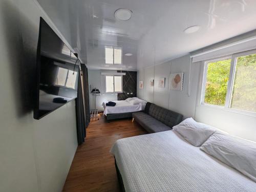 a room with two beds and a couch and a tv at Tierra de Gosén in Santa Cruz