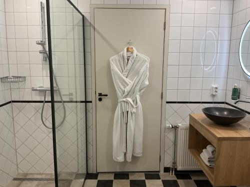 a robe hanging on a shower door in a bathroom at Graanzicht in Midwolda