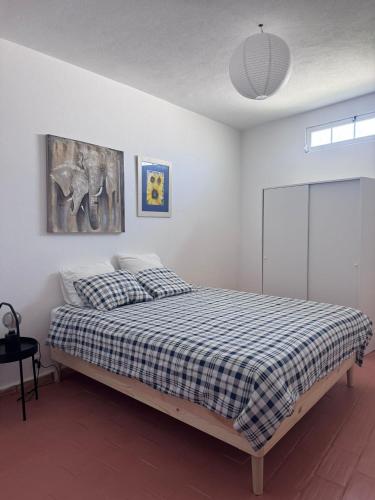 a bedroom with a bed with a checkered blanket at Sirocco Pool House in Carvoeiro
