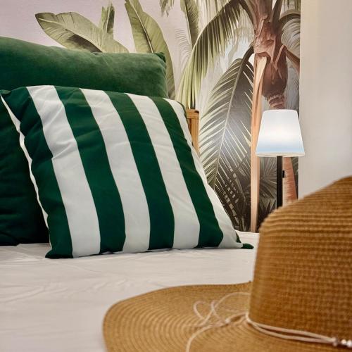 a bed with a green and white pillow and a lamp at Ti Paradis with Private rooftop in Grand-Baie
