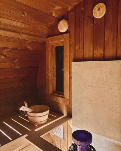 a small room with a tub in a cabin at Black Cabin Veluwe - Wellness in het bos - Airco & Sauna in Putten