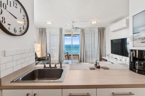 a kitchen with a sink and a clock on the wall at Beachfront apt with amazing views in Stella