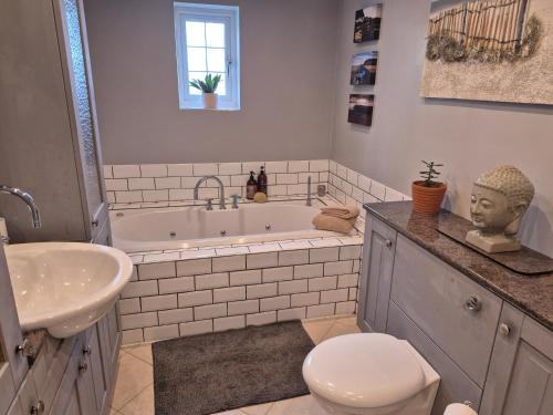 a bathroom with a tub and a toilet and a sink at Coast to Coast Accom - Shap in Shap