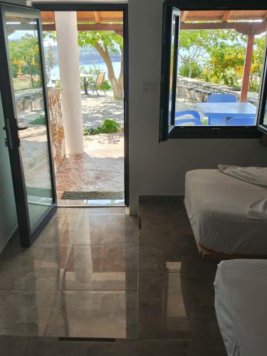 a room with two beds and a view of a patio at John's Guesthouse in Ksamil