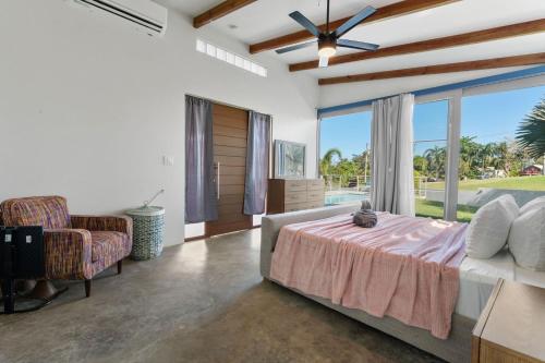 a bedroom with a bed and a large window at Casa Palma y Sol with private pool in Aguada