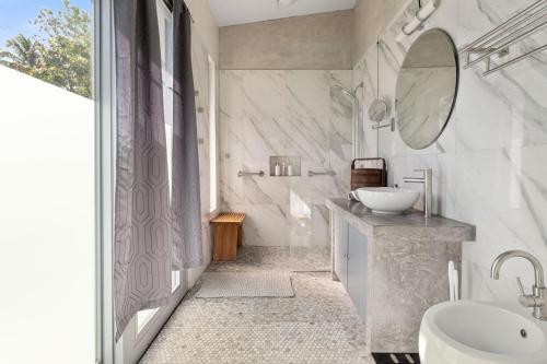 a white bathroom with a sink and a mirror at Casa Palma y Sol with private pool in Aguada