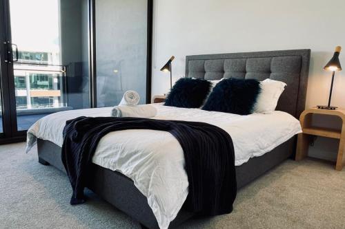a bedroom with a large bed with black and white pillows at Big, Bold, Barton in Barton