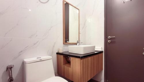 a bathroom with a sink and a toilet and a mirror at 3 Bed Room One Residence by momo in Pulau Sembakau Kecil