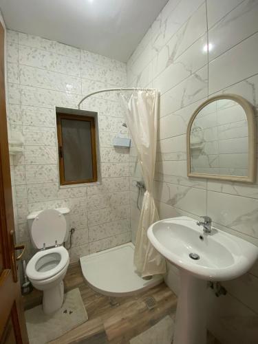 a white bathroom with a toilet and a sink at St Julians Mansion Rooms in St. Julianʼs