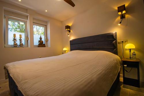 a bedroom with a large bed and two windows at Casa Les Fremeaux in Altea