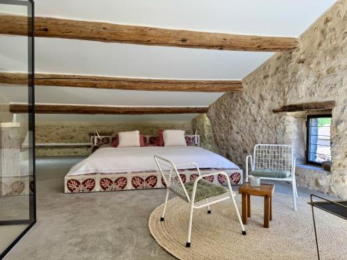a bedroom with a bed and two chairs at Domaine de Ribaute in Lieuran-lès-Béziers