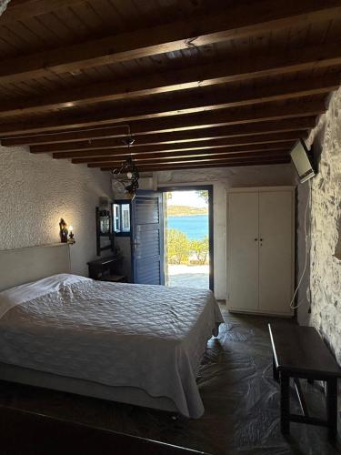 a bedroom with a bed and a view of the ocean at Villas Kalafatis Apartments in Kalafatis