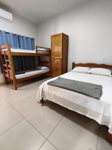 a bedroom with a large bed and a chair at Criptos Hotel e Restaurante in Várzea Grande