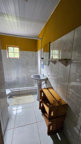 a bathroom with a sink and a toilet and a tub at Pousada do Artista in Conceição da Ibitipoca