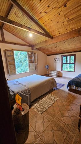 a bedroom with a large bed in a wooden ceiling at Pousada do Artista in Conceição da Ibitipoca