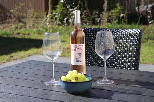 two wine glasses and a bowl of grapes on a table at Sola Lodge - Luxe chalet voor het hele gezin in Mariënberg