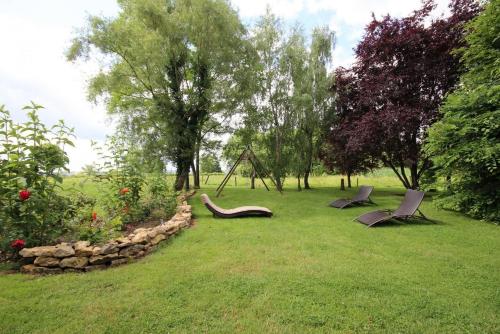 two chairs sitting in the grass in a garden at La Chaume en Loire in Devay