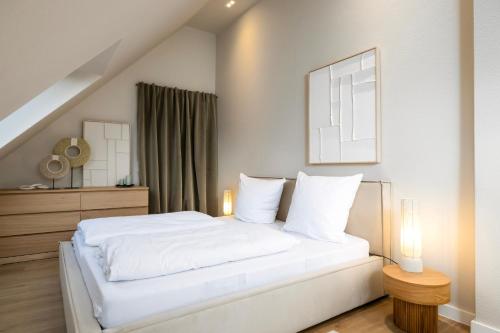 a bedroom with a white bed and a window at Stylische Penthouse - Maisonette - Wohnung im edlem Design mit Balkon, Dachterrasse und kostenloser Tiefgarage im Herzen von Markkleeberg - Neuseenland in Markkleeberg