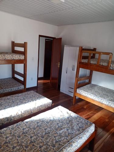 a room with three bunk beds and a door at Casa de temporada em Araruama in Araruama