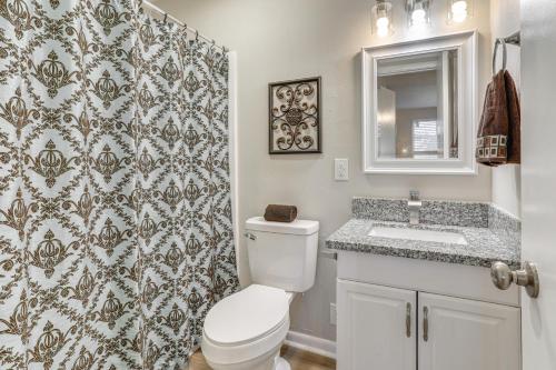 a bathroom with a toilet and a sink and a mirror at Tiger Town Retreat: Spacious 3-Home Retreat! in Baton Rouge