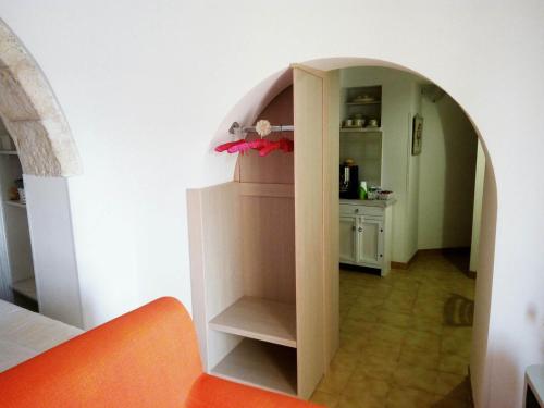 a room with an archway in a room with a kitchen at Trullo Sereno Angelo in Locorotondo