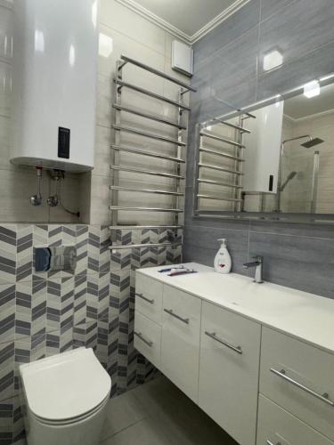 a bathroom with a toilet and a sink and a mirror at Golden Era Relax in Odesa