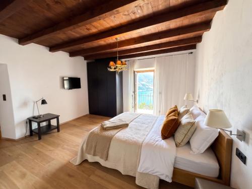a bedroom with a bed and a large window at Casa borgo Arias Lake View in Tremosine Sul Garda