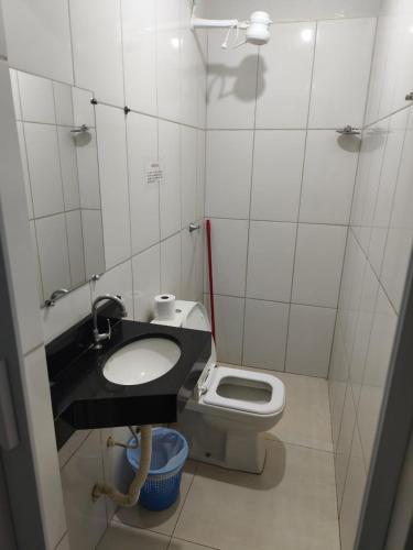 a small bathroom with a sink and a toilet at Criptos Hotel e Restaurante in Várzea Grande