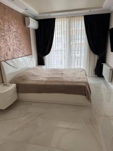a bedroom with a bed and a large window at Golden Era Relax in Odesa