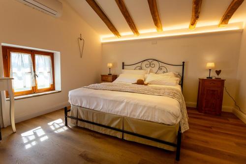 a bedroom with a bed with a cat laying on it at Ca'Bastian-Guest House in Moruzzo