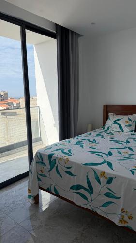 a bedroom with a bed and a large window at Kevin Island House in Ilhéu de Santa Maria