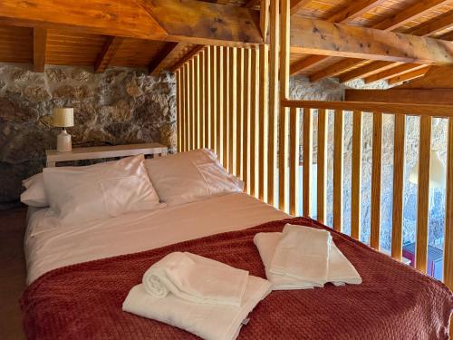 a bed with two towels on it in a room at Quinta da Bela Vista do Lima in Ponte de Lima