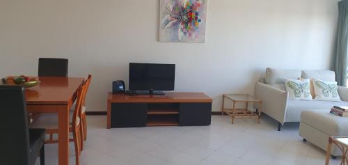 a living room with a couch and a table with a tv at Penthouse with panoramic view in Vilamoura
