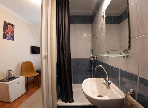 a bathroom with a sink and a shower at Mátyás Szállás Panzió in Szombathely