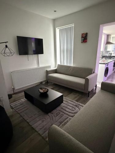 a living room with a couch and a coffee table at Large 6 Bed 6 Bathroom House - Ideal For Families, Large Groups, Contractors & Business Travellers in Watford