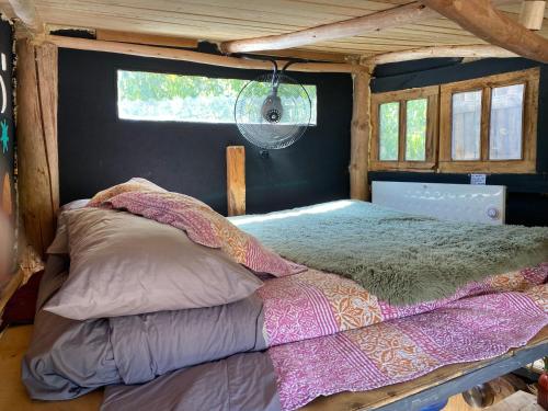 ein großes Bett in einem Zimmer mit Fenster in der Unterkunft Barbablancaspa in San José de Maipo
