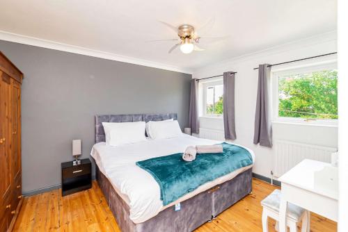 a bedroom with a bed and two windows at Comfortable 3BED House with Garden & Parking in Colchester