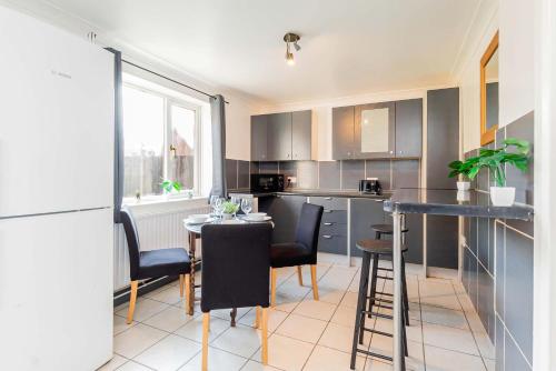 a kitchen with a table and chairs in a room at Comfortable 3BED House with Garden & Parking in Colchester