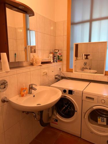 a bathroom with a sink and a washing machine at Surya Villa Holistic Stay Prenzlauer Berg in Berlin