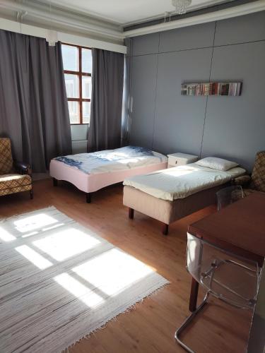 a bedroom with two beds and a table at Willa Witsari 27m2 in Kokkola