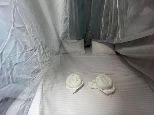 a bed with two white towels on it at Tsamuna Ecolodge Macedonia in Macedonia