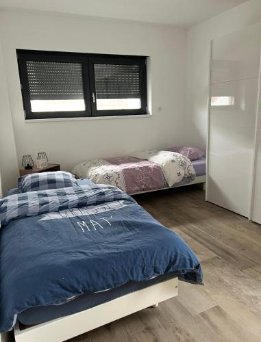 a bedroom with two beds and a mirror at Villa Aqua Détente in Colmar
