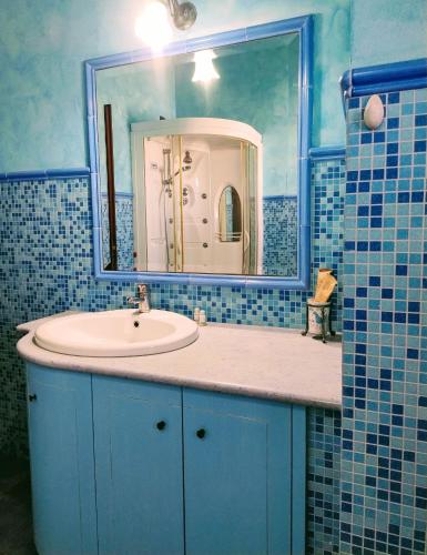 a blue bathroom with a sink and a mirror at B&B Sa Sinniesa in Sìnnai