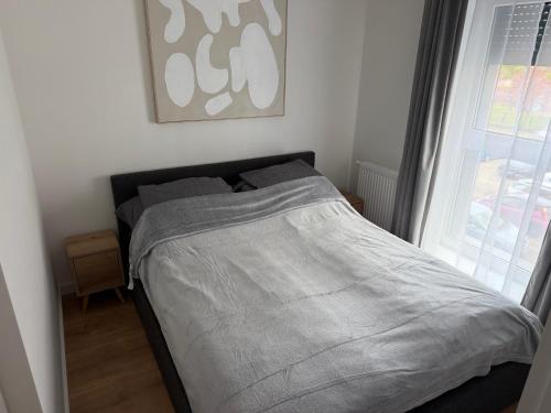 a bed in a bedroom next to a window at Apart Apartamenty Łowiecka 4A Free Parking in Leszno