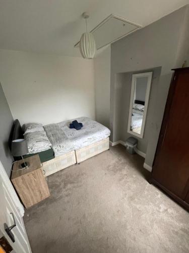 an empty bedroom with a bed and a mirror at The Crandale Road House in Bath