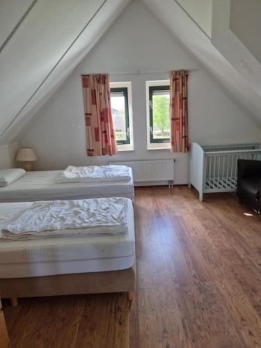 a bedroom with two beds in a attic at vacation home 68 in Tzummarum