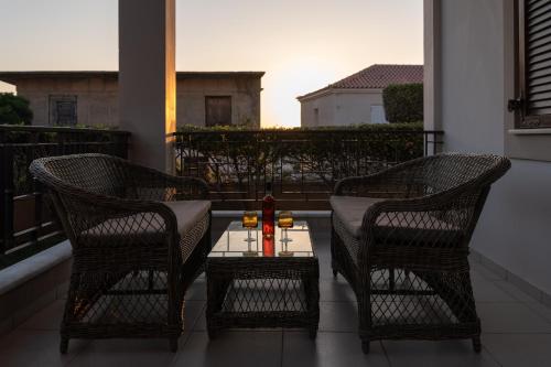 two chairs and a table on a balcony at Iliodysi Houses in Methoni